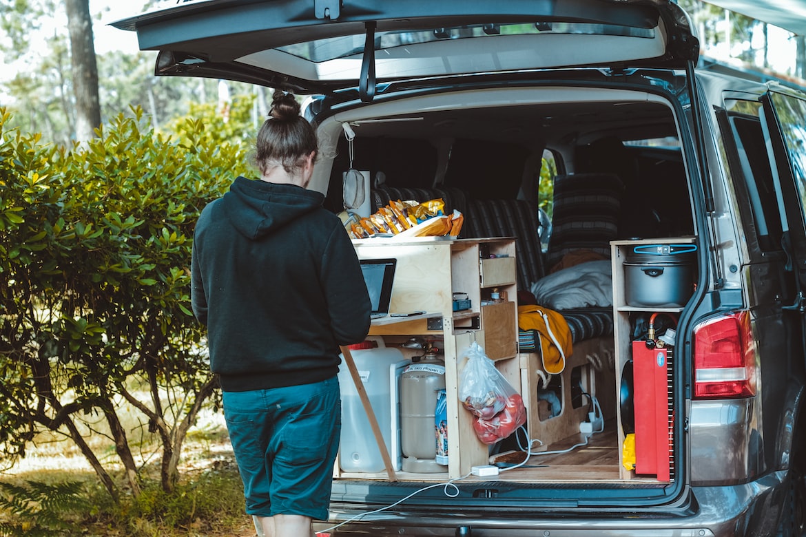 Man Stands Next to an Equipped Campervan